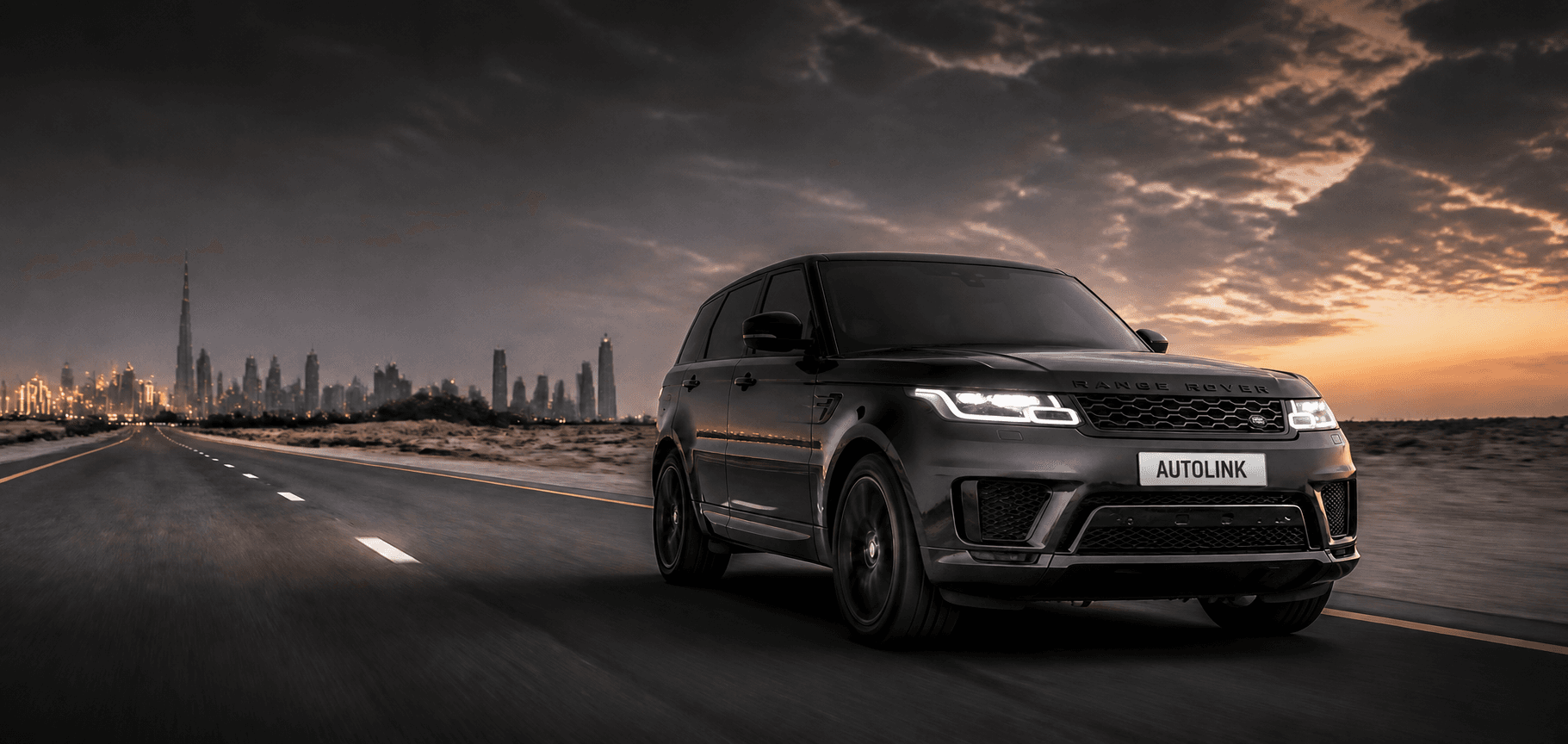Dark SUV driving on an open road towards the Dubai skyline at dusk